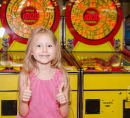 little girl standing and playing at indoor amusement park