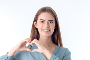 beautiful smiling girl showing hands heart isolated on white background