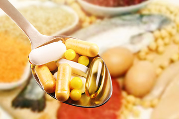 dietary supplements in spoon on protein food background