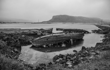 The old flooded wooden boats in water of the Barents Sea, Teribe