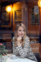 Woman waiting inside an elegant cafe