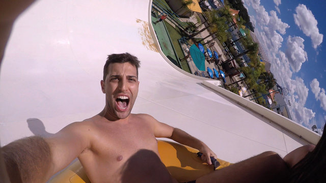 Man having fun and sliding down in a water slide