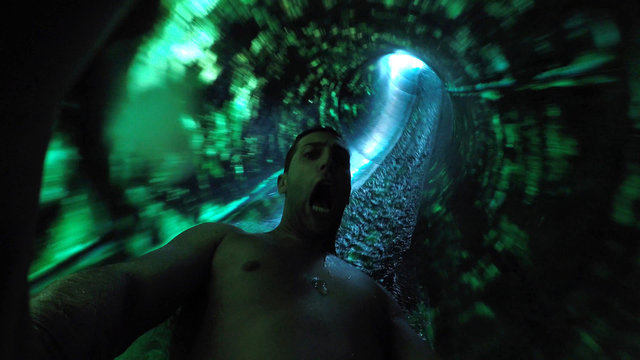Man having fun and sliding down in a water slide