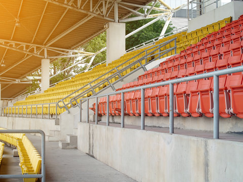 row of empty stadium grandstand seats in sport arena with evening sunlight