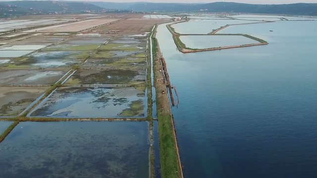 Flight over soline in Slovenia on sunset, place of extraction of sea salt, aerial panoramic view. Secovljske Soline, Slovenia.