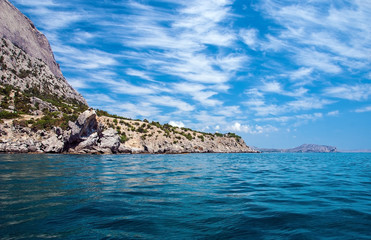Fototapeta na wymiar Landscape with sea in the foreground, a mountainous distant shore, blue sky with a pattern of Cirrus clouds. Crimea.