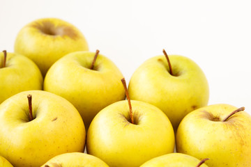Golden delicious apples on light beige background with copy space