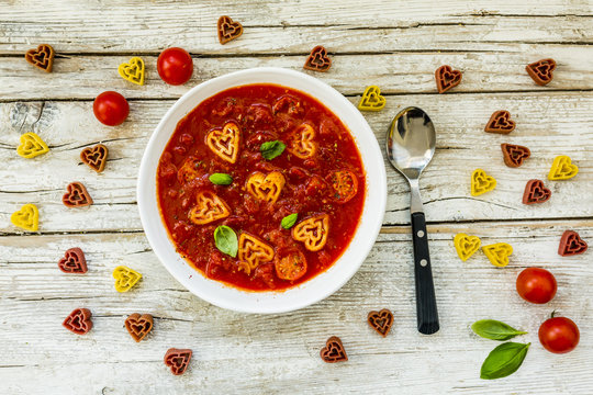 Tomato soup with heart-shaped pasta and basil on Valentine's Day.
