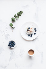 Breakfast with cup of coffee, sweet dessert, blueberry. Flat lay, top view