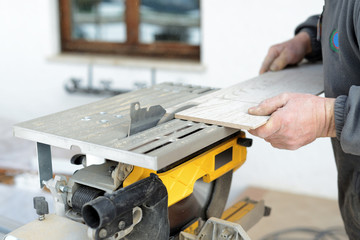ristrutturare casa - mani di operaio che tagliano il parquet
