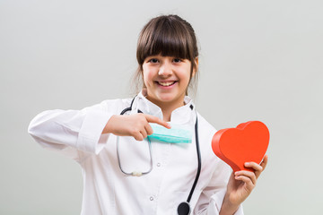 Beautiful little cardiologist showing heart shape.
