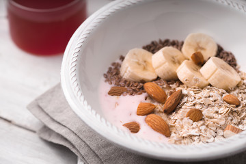 Fruit yogurt with different toppings on the white wooden table  horizontal