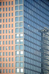 Fototapeta premium Moderne Hochhausfassade / Die moderne Fassade eines Hochhauses mit Spiegelungen in den Fenstern.
