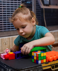 happy little caucasian girl playing with cubes