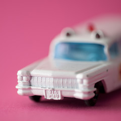 White toy ambulance on fuchsia background