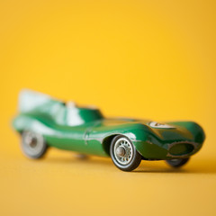 Toy sports car on yellow background