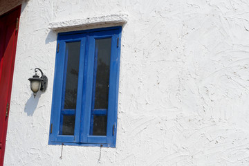 Blue wood window on rough white wall