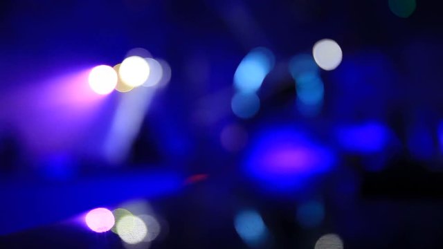 Defocused scene in the night club with bokeh lights and people silhouettes