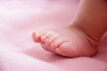 stopa małego dziecka na różowym kocu