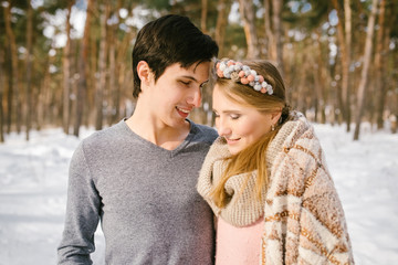 Fototapeta premium Outdoor happy couple in love posing in cold winter weather. Young boy and girl having fun outdoor