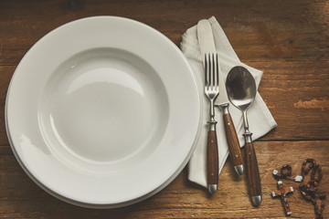 Empty place setting with rosary and copy space
