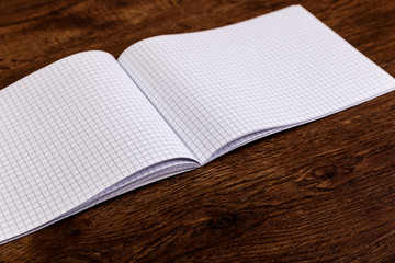 Notepad on the wooden rustic desk. Mockup design concept with empty notebook page. Mock-up of blank diary. Wooden rustic desk.