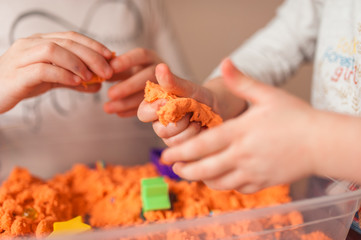 hands of a kid playing with magic sand