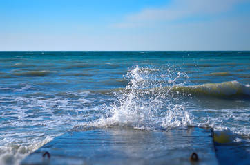 Sea waves crashing against the concrete pier