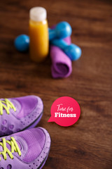 Fitness gym equipment. Sneakers, dumbbells with towel. Time for fitness speech bubble. Fresh orange juice drink. Grunge rustic wood background.