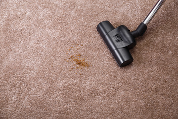 Vacuuming carpet with vacuum cleaner. Dirt on the rug. Housework service. Close up of the head of a...