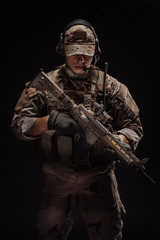 Portrait soldier or private military contractor holding sniper rifle