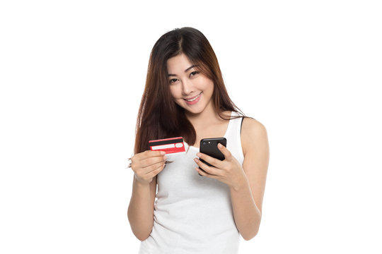 Young beautiful girl using credit card and mobile phone making transaction isolated on white background