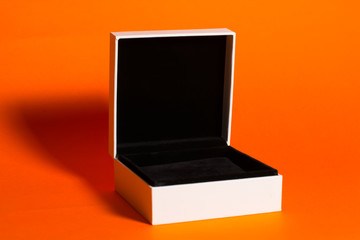 Opened white gift box on a orange background