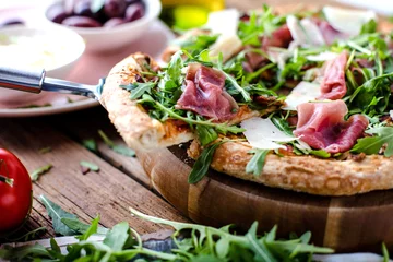 Foto op Plexiglas Pizzeria Verse pizza met ham en rucola