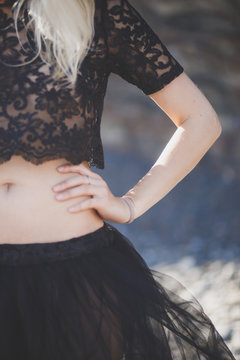 girl with beautiful figure in the black delicate lace the bodice and skirt of tulle with an open belly waist close-up blonde