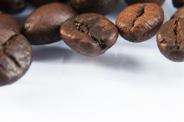 Photo macro coffee beans on a white background.