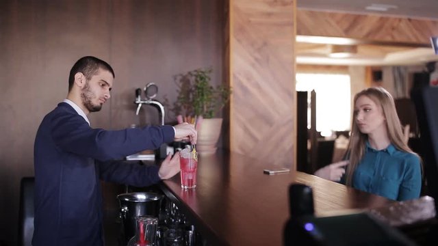 Handsome bartender making cocktails for beautiful women in a classy bar