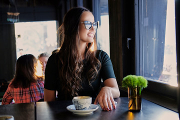 Smiling brunette woman in a cafe.