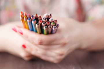 Bunch of colored pencil in woman hands