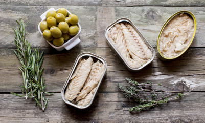 
Canned fish and olives on rustic wooden boards