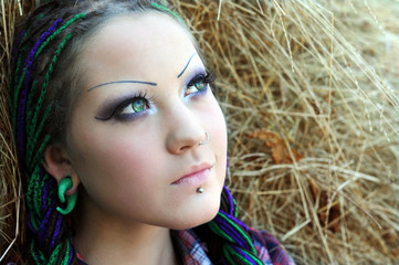 close-up portrait of young stylish woman with green eyes on haystack background