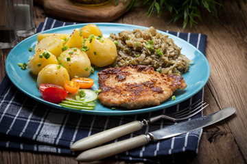 Fried pork chop, baked potatoes and fried young cabbage.