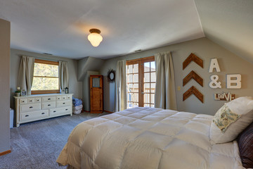 Tranquil bedroom with sloped ceiling and doors to nice deck.