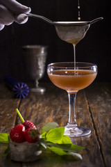 Strawberry and mint cocktail, on a dark wooden background, filtered through a sieve
