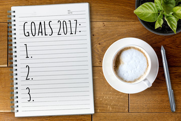 View from above on the table with a notebook and goals for 2017