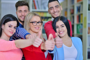 Cheerful group of students smiling at camera with thumbs up, success and learning concept