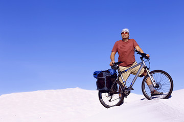 Fototapeta na wymiar Traveling man on a bicycle in the desert.