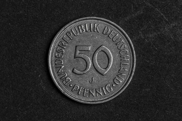Naklejka na ściany i meble Close up of 50 German Pfennig coin on black background - business concept