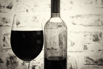Bottle of red wine with glass ready to pour