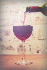Glass of full bodied red wine being poured